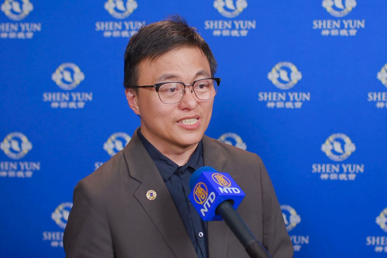 '图8:二零二五年四月十五日晚上,摄影工坊艺术总监郝振平在高雄观赏了神韵演出。(新唐人电视台)'