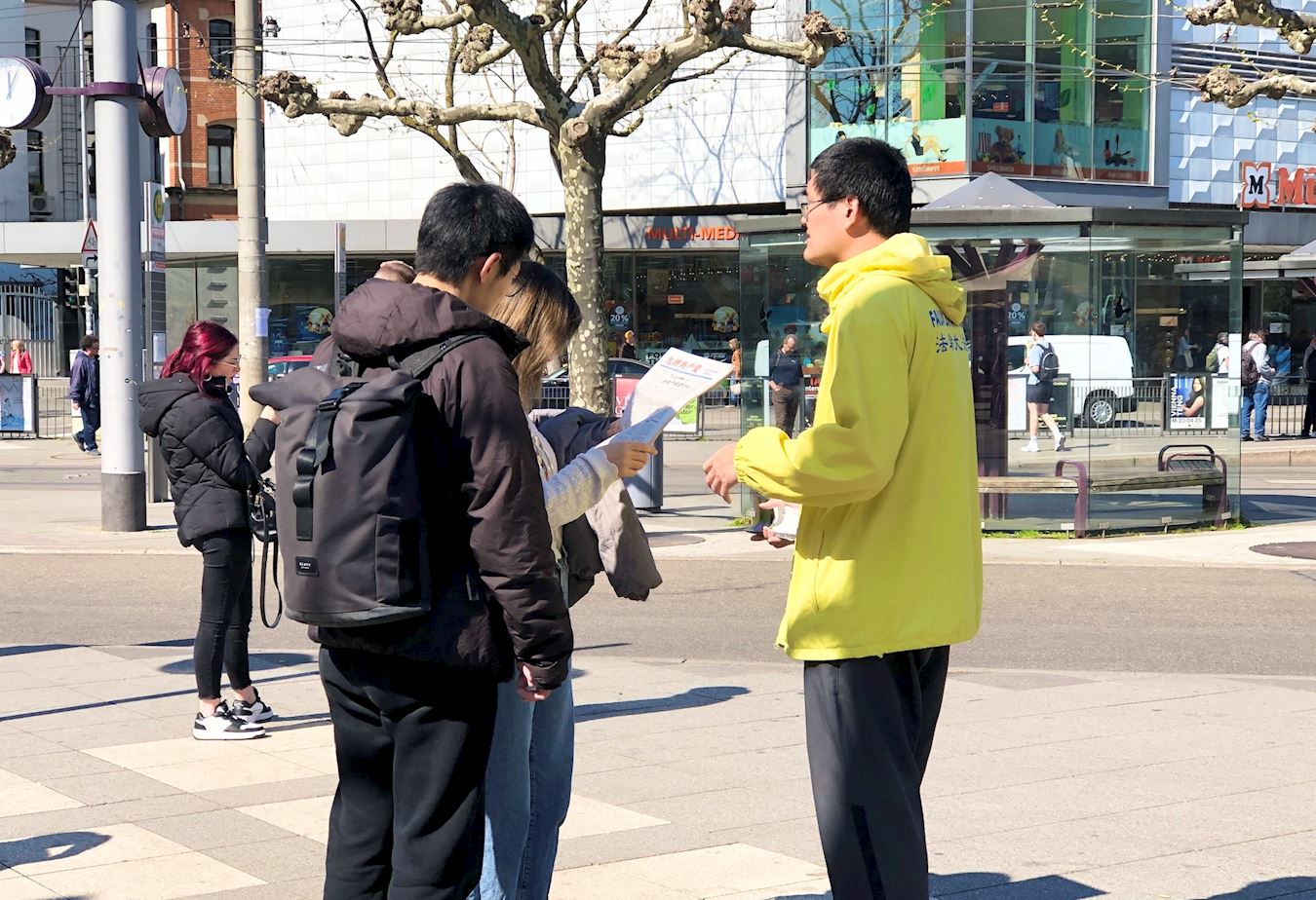 '图11:两位中国留学生在认真阅读大纪元特刊《九评共产党》。'