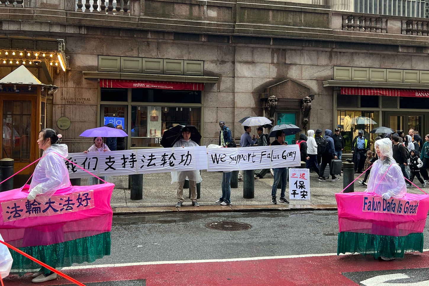 图12:纽约华人民众代表在法轮功学员庆祝5‧13法轮大法日游行的途中举横幅表达他们支持法轮功的心意。(大纪元)