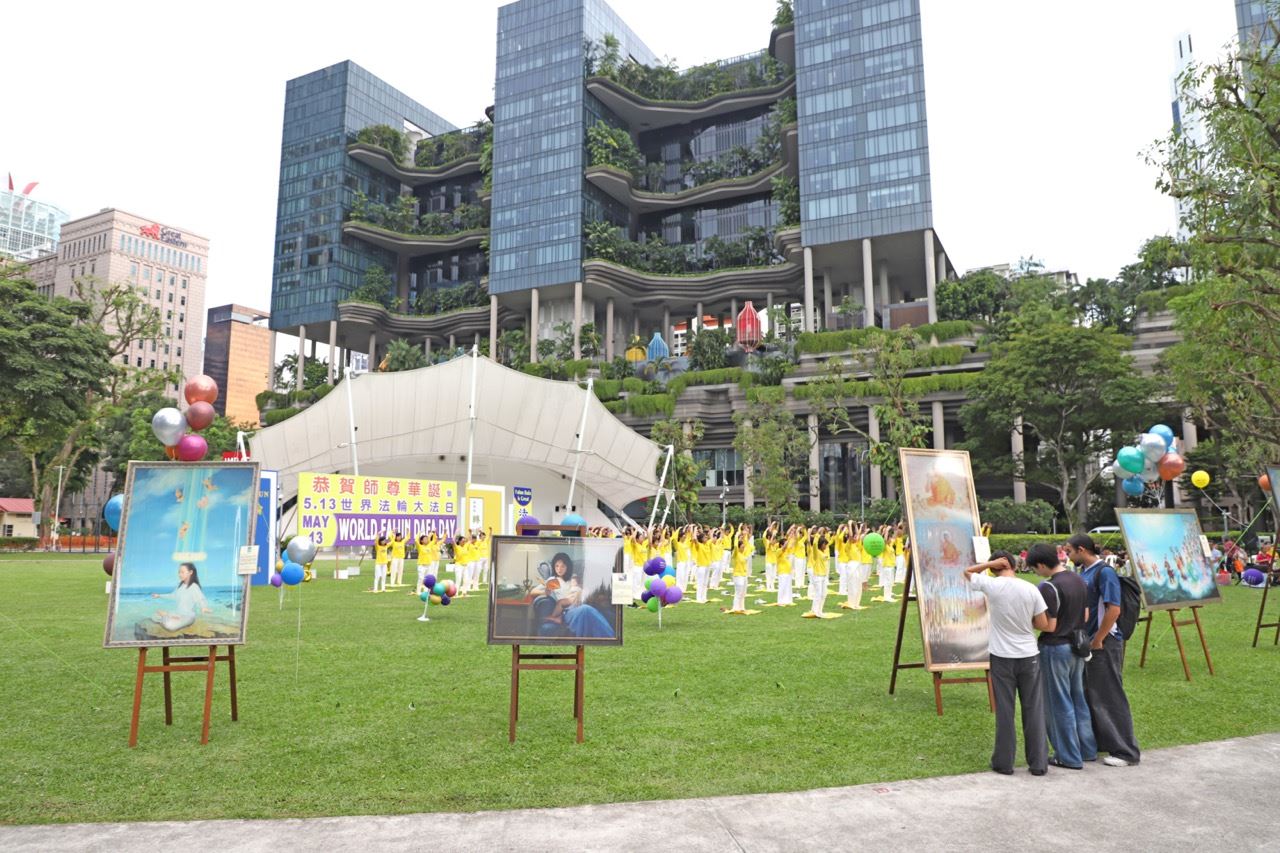 '图6:新加坡芳林公园的人行道边展示的多幅“真善忍美展”画作。'