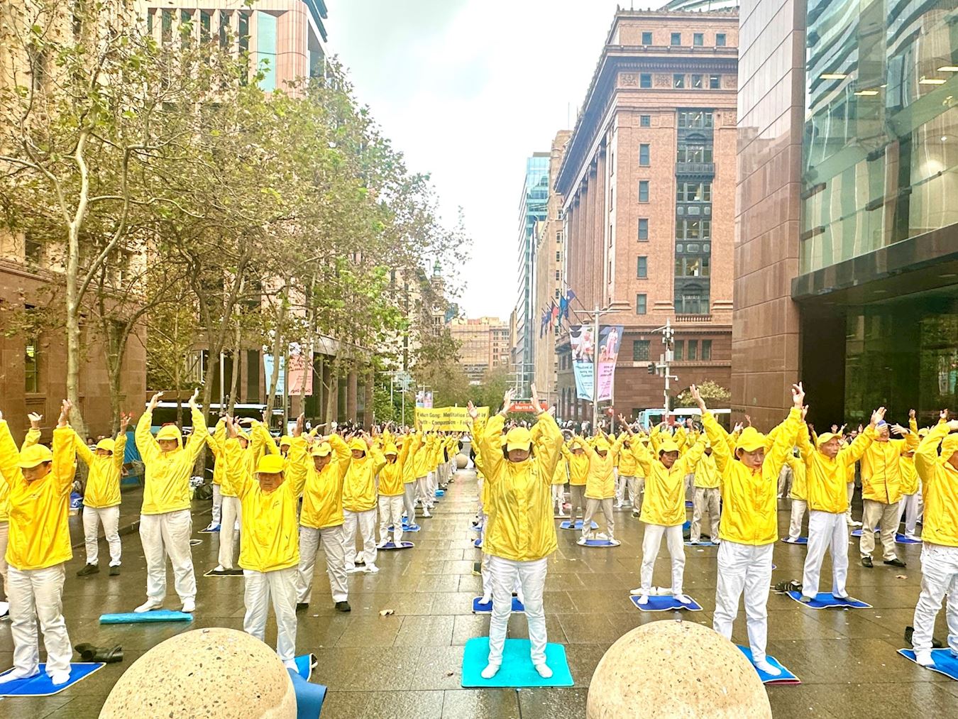 '图17~18:二零二五年五月八日,法轮功学员在悉尼马丁广场欢庆世界法轮大法日,举行集体晨炼,展示大法美好。'