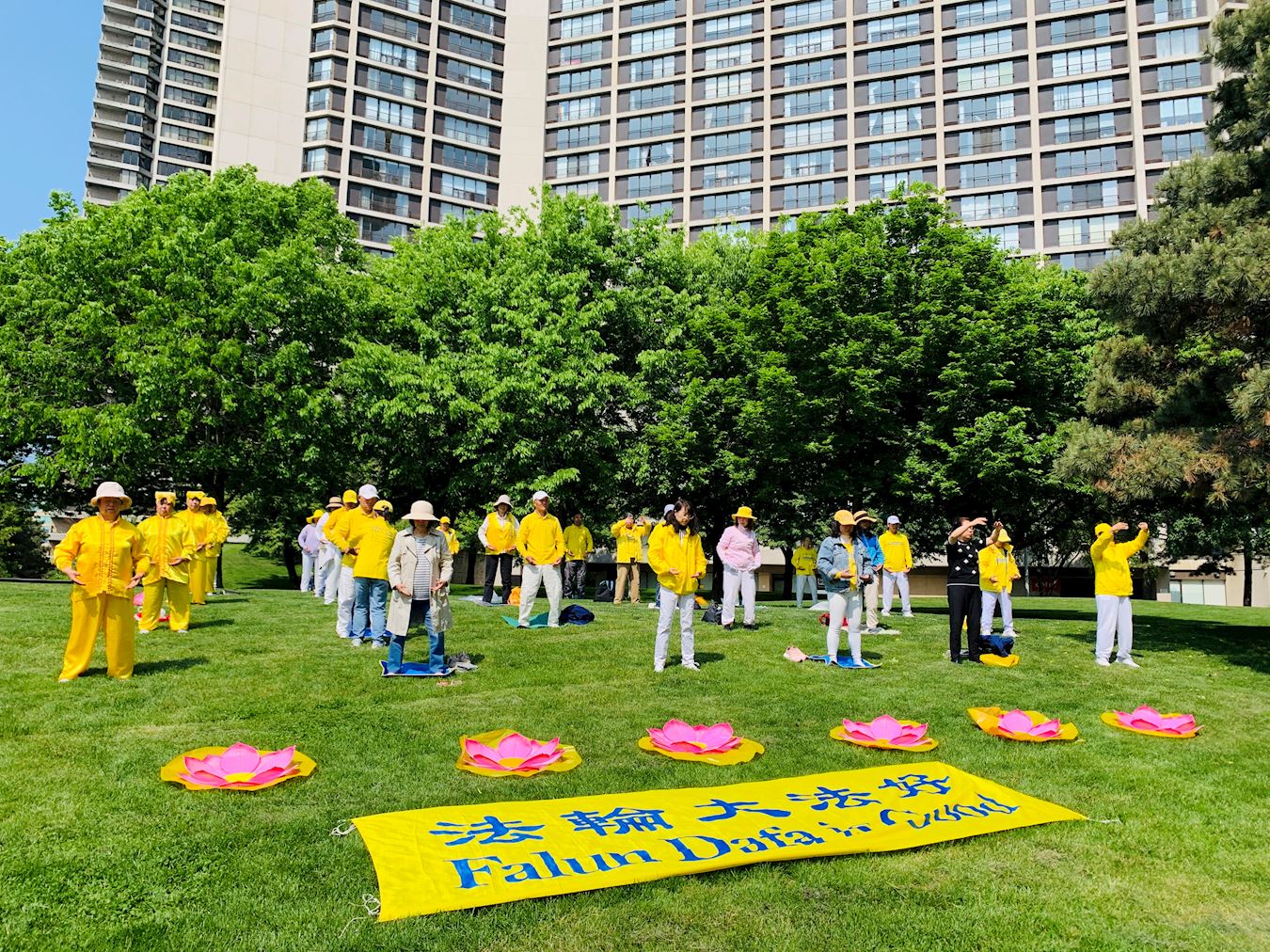 '图1~2:多伦多的法轮功学员们在码头广场公园(Harbour Square Park)的大草坪上集体炼功'