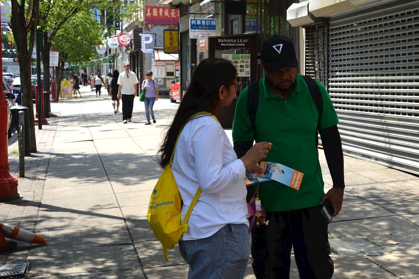 '图13:商店经理大卫·特拉维克(右)在聆听法轮功学员讲真相。'