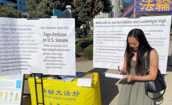 '图6:圣地亚哥县北郡波威市议员珍妮·麦达观看了画展并和法轮功学员长时间交谈,了解真相。她并为呼吁美国参议院通过《法轮功保护案》征签。'
