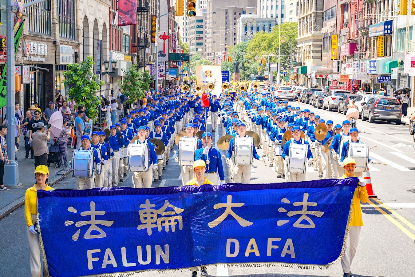 '图1~3:二零二五年七月二十日,法轮功学员,包括数百位神韵艺术家,在纽约曼哈顿的华埠举行法轮功反迫害26周年大游行。图为行进中的天国乐团和神韵艺术团方阵。'
