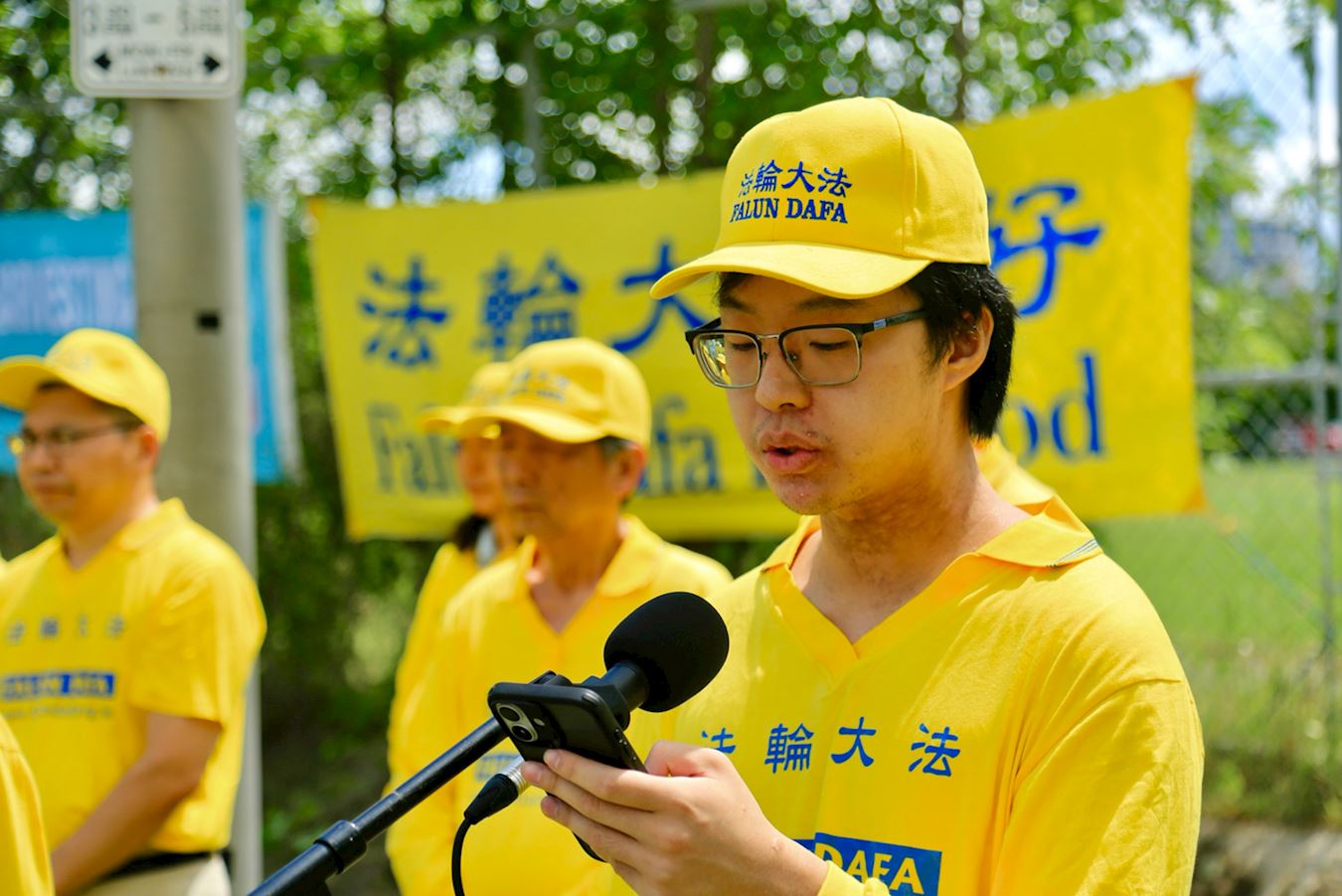 '图4:二零二五年年七月二十日,在加拿大首都渥太华中使馆前,今年二十六岁的中国留学生刘之源诉说自己家庭26年来遭受的迫害。'