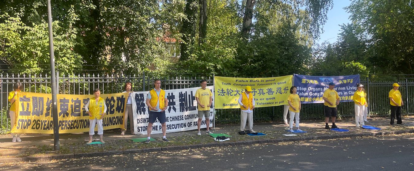 '图1:法轮功学员在中共驻丹麦大使馆前炼功、打坐反迫害:立即停止迫害法轮功。'