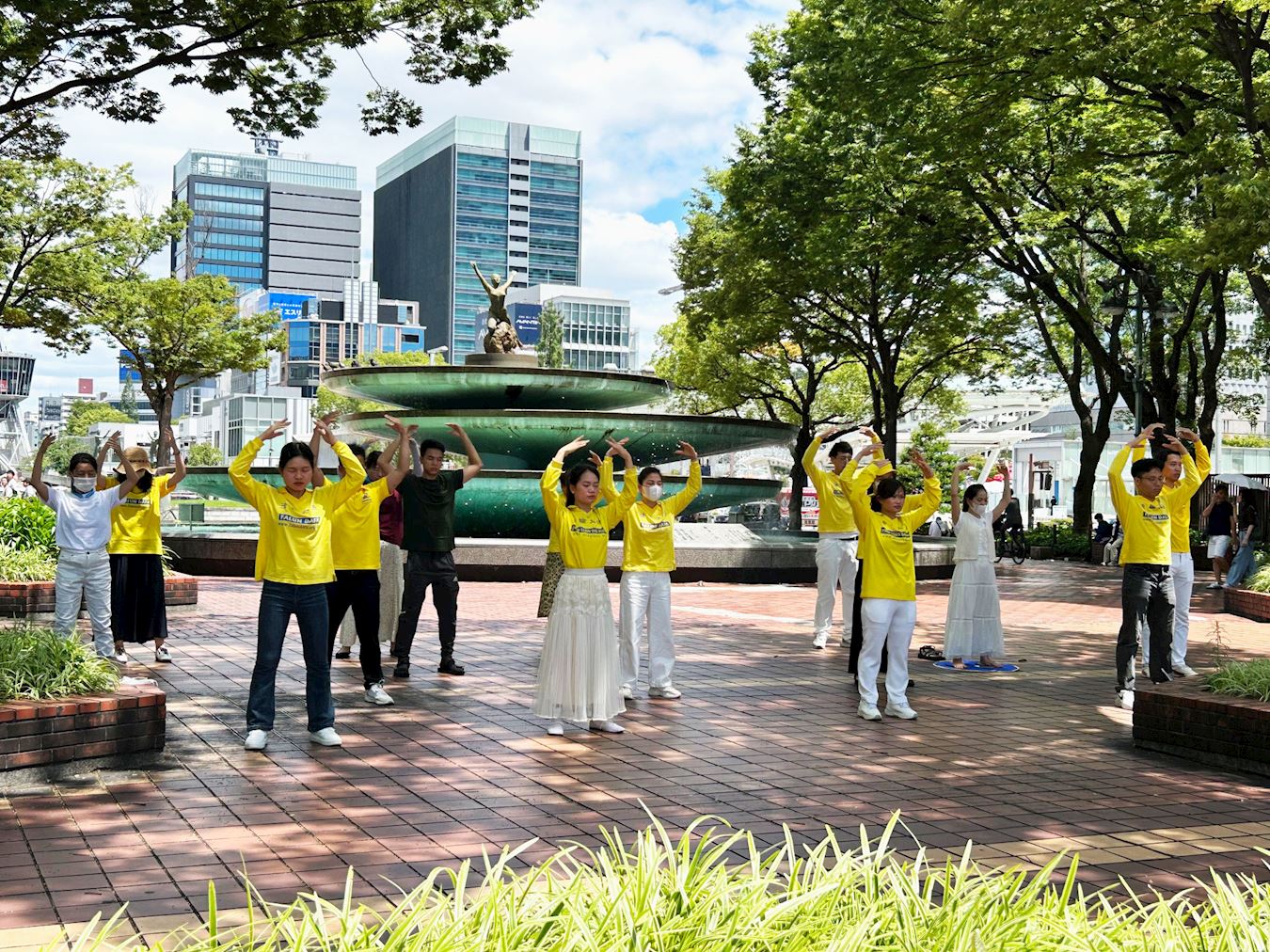 '图1~2:二零二五年七月二十日,法轮功学员们在名古屋市“荣”喷水附近炼法轮功的五套功法'