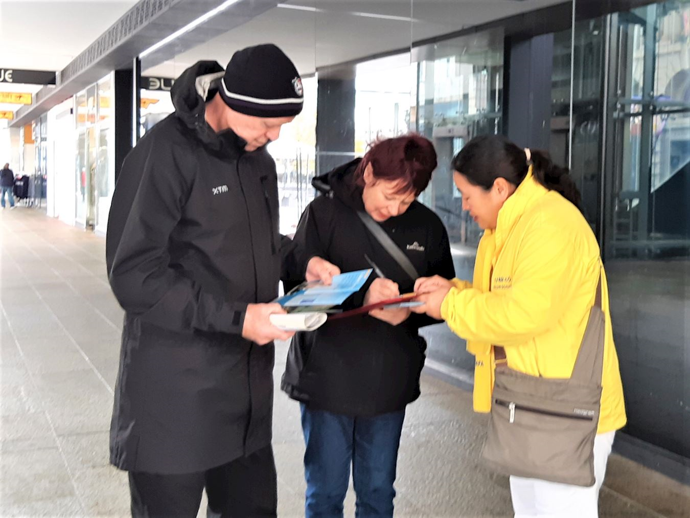 '图12~13:二零二五年七月二十日,西澳法轮功学员在珀斯市区步行街举办集会活动。路人签署支持法轮功学员反迫害的请愿书。'