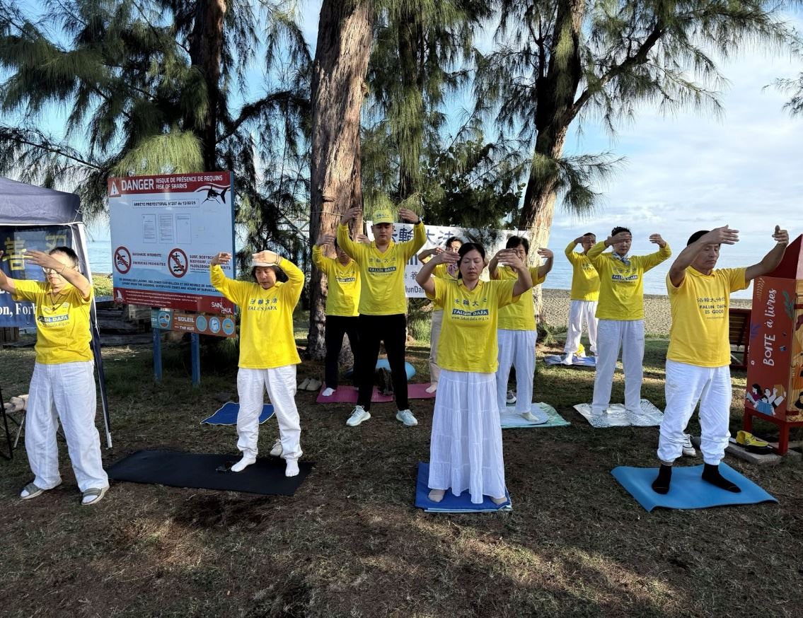 '图1:留尼汪岛法轮功学员在圣保罗市中心设立的信息展台前展示功法'