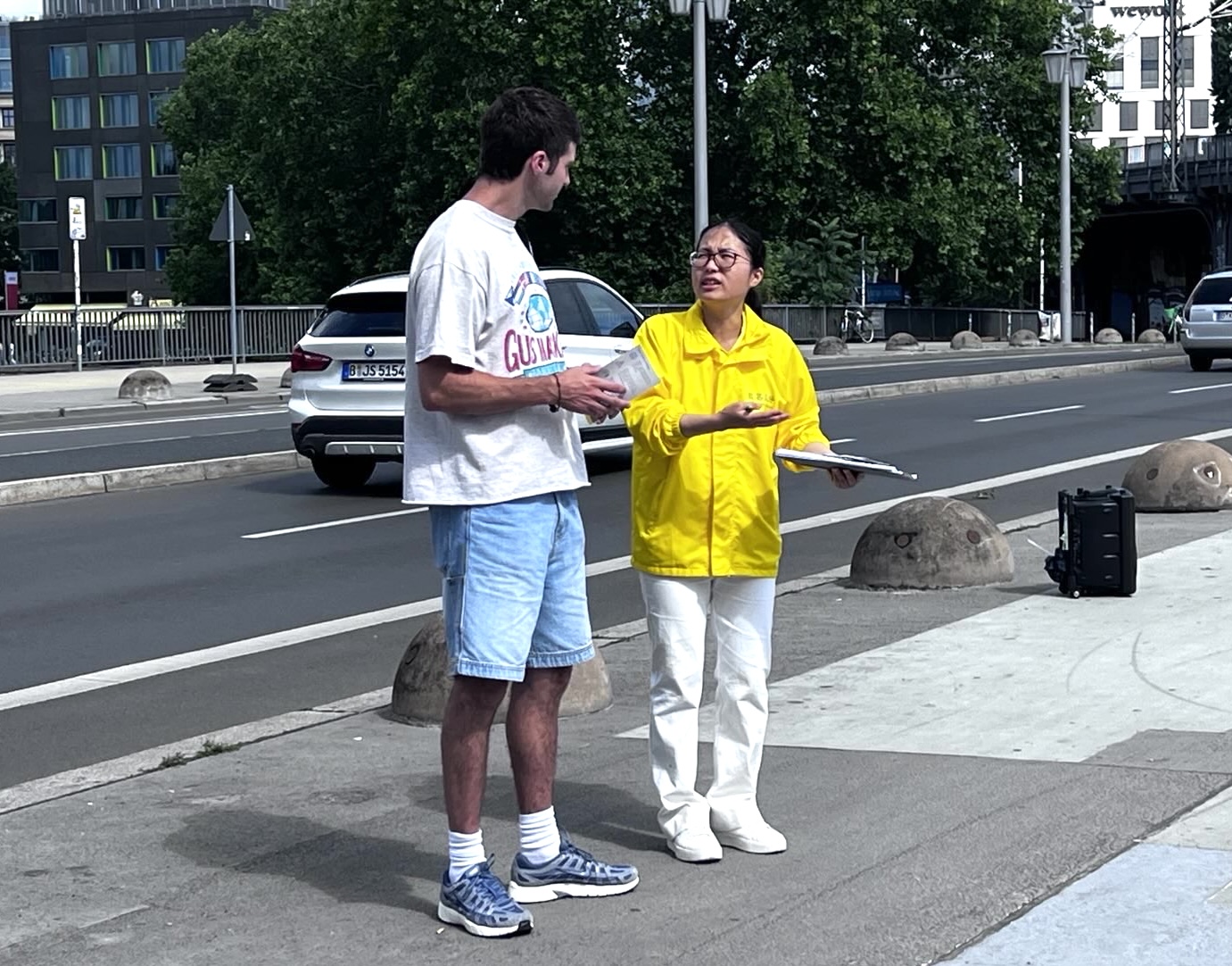图5:柏林路人与法轮功学员交谈,想了解更多法轮功的讯息。