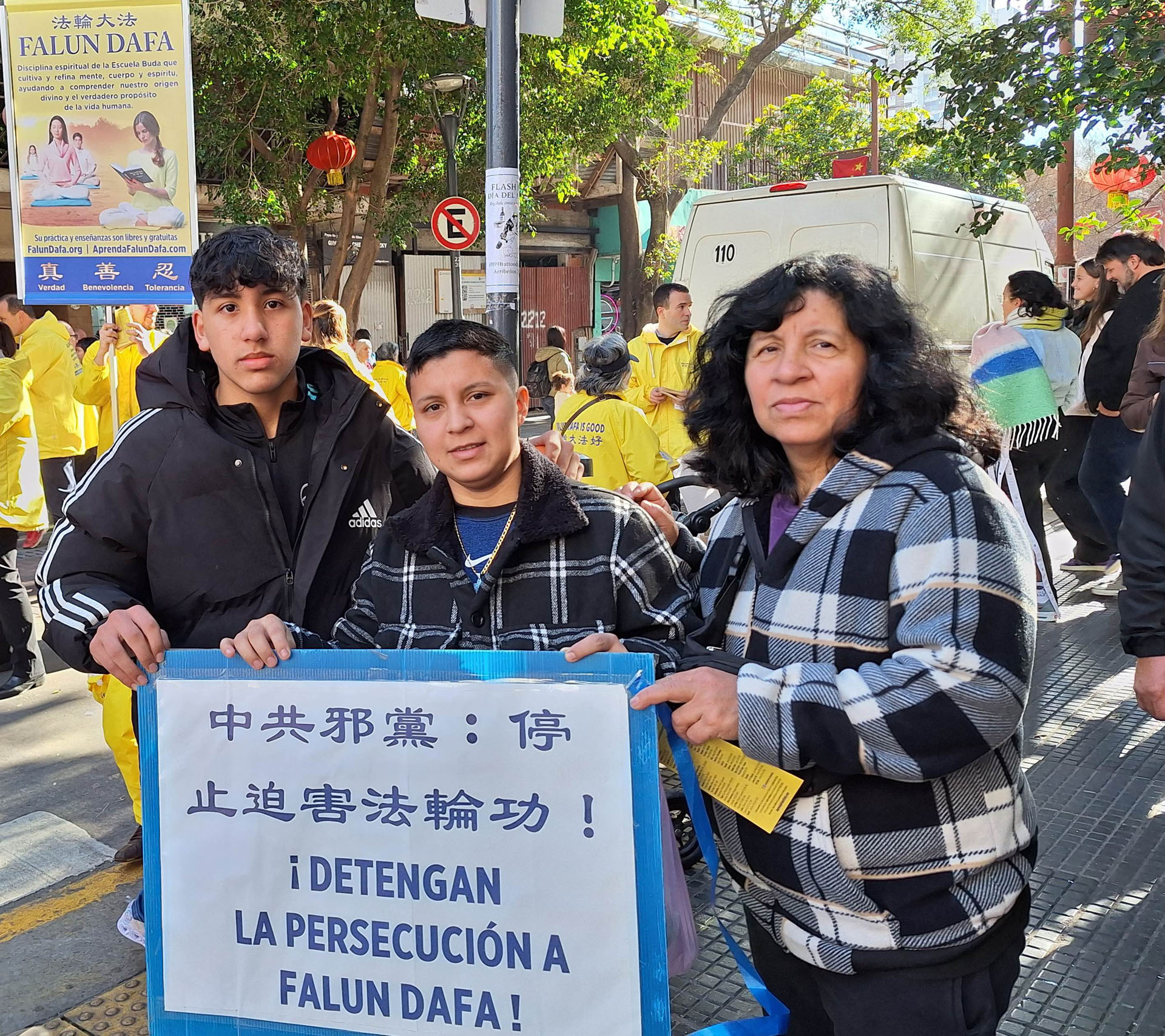 图7:盖卜里拉(Gabriela)与她的两个儿子举着写有“停止迫害法轮大法”的标语。他们对中国发生的宗教信仰迫害感到震惊。