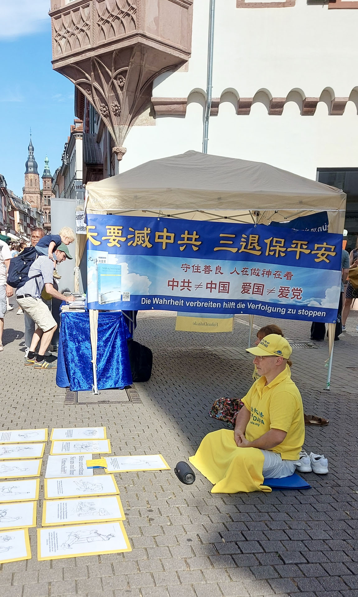 图1:二零二五年七月五日, 德国法轮功学员在海德堡剧院广场(Theaterplatz)征签反迫害。图为法轮功学员在炼功。