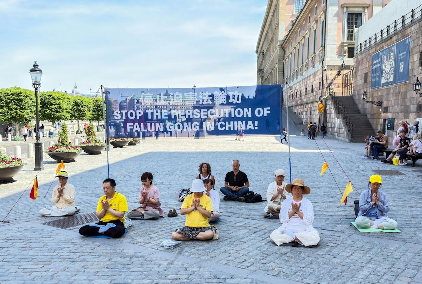 '图5:来自葡萄牙的一对旅游夫妇,了解真相后径直走上前和法轮功学员在一起静静地坐了很久。'