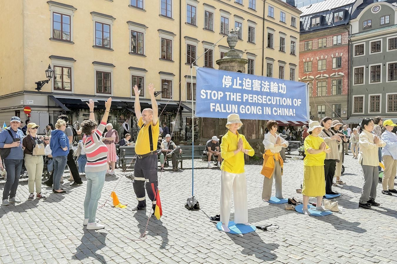 '图9:不少人对法轮功感兴趣,有人当场就学炼功法动作。'