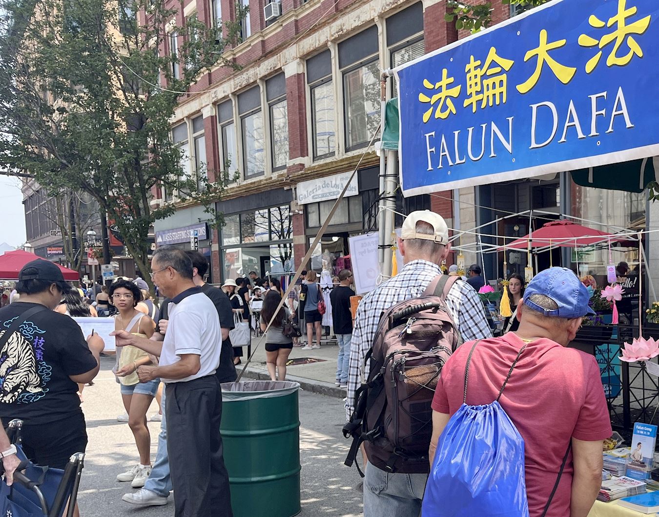 '图1~3:二零二五年七月二十六日和二十七日,法轮功学员在娄尔民俗节庆活动中设立了法轮功真相展位。很多人停下来听真相并签名要求联邦参议院能尽速通过《法轮功保护法案》。'