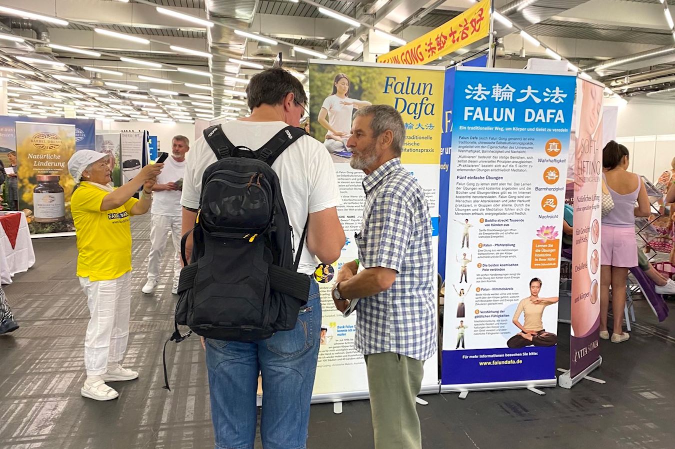 '图3~4:学员向观展者介绍法轮功。'