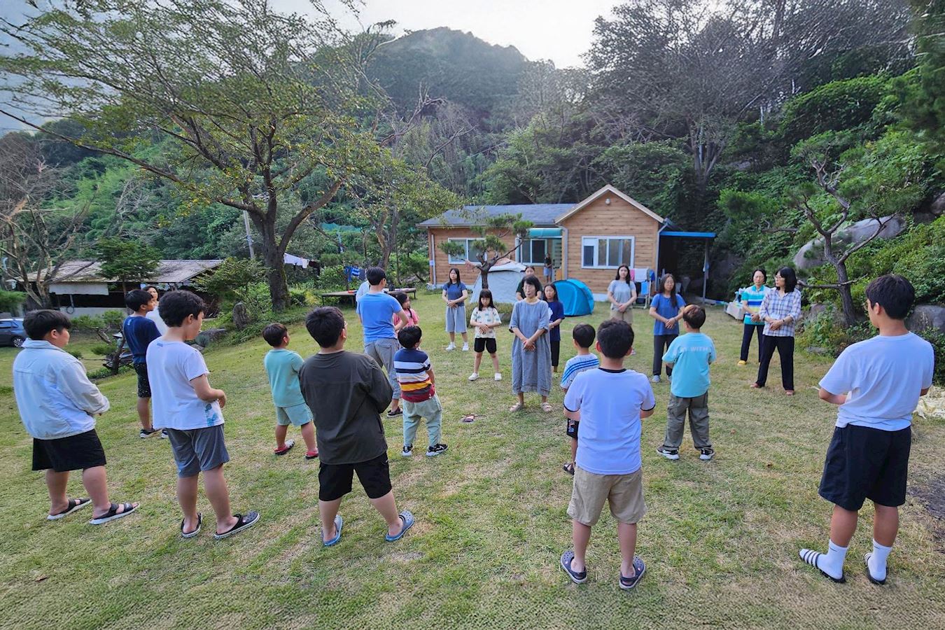 '图2~5:夏令营期间,孩子们每天集体阅读《转法轮》和背诵《洪吟》,并学习五套功法。'