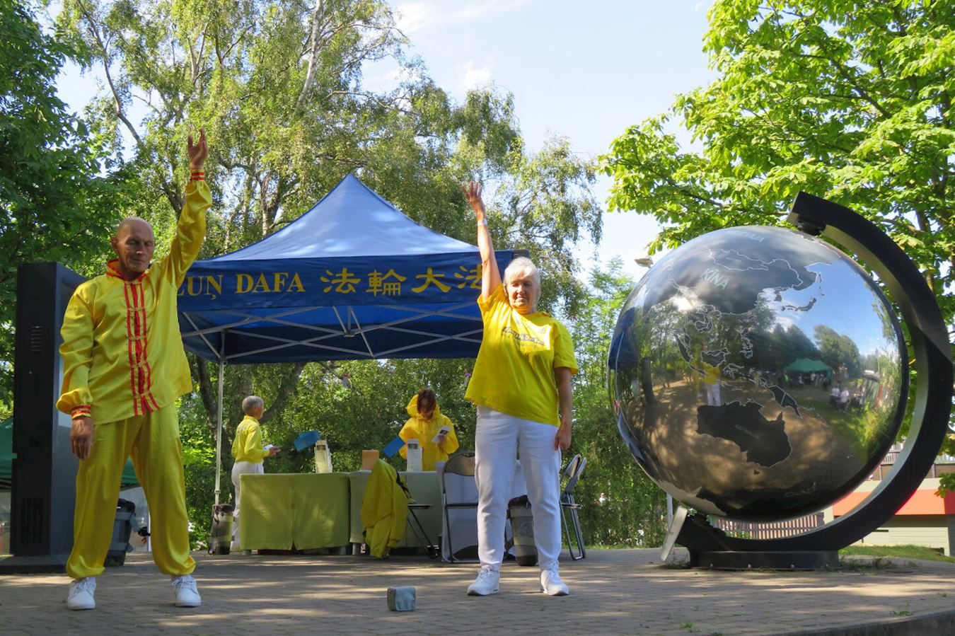 '图1~2:二零二五年八月十六日,拉脱维亚法轮功学员在青年节上向民众展示功法。'