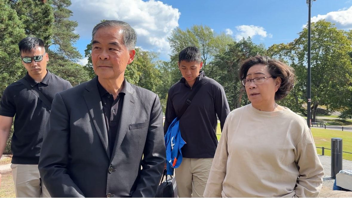'图1~2:香港前特首梁振英与其妻梁唐青仪在芬兰威胁法轮功学员'