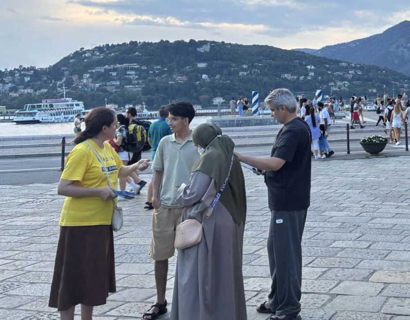 '图9~11:八月十七日在意大利北方与瑞士接壤的科莫市,法轮功学员把法轮大法的福音带到了这个美丽宁静的城市。'