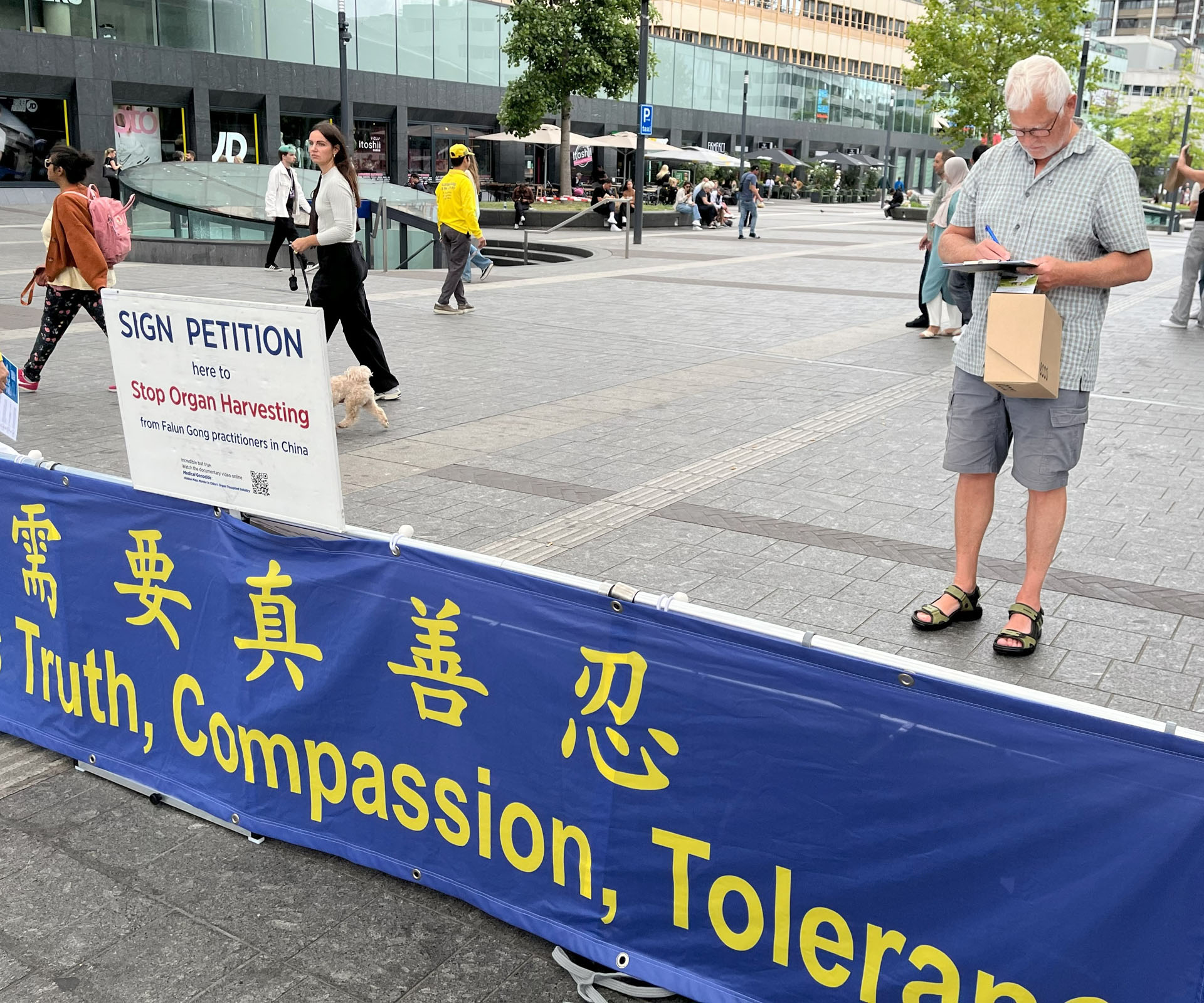 图9:一位荷兰男士阅读了真相资料后签署请愿书。