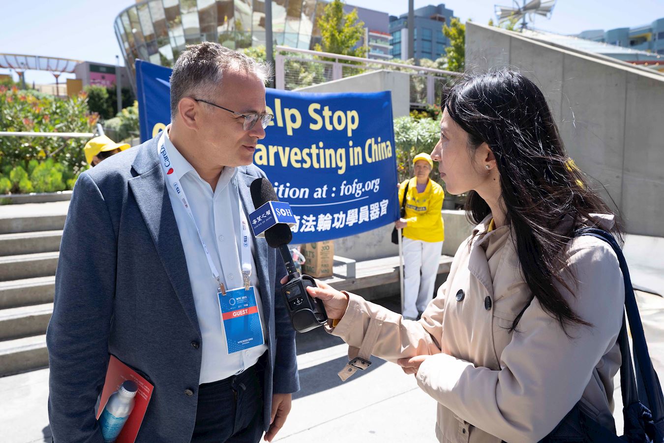 '图11:参加移植大会的俄罗斯医生贾拉明(左)表示,国际社会应该帮助制止活摘器官行径。'