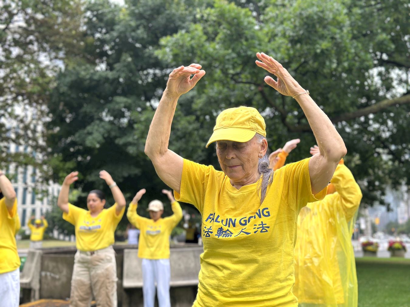 '图1:即使下着细雨,妮可仍然参加集体炼功活动。'